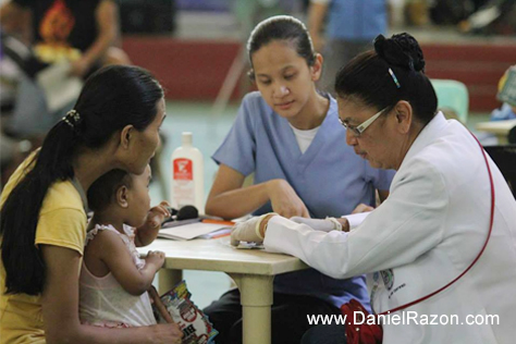 Dr. Cabanilla giving instructions to a patient as a volunteer nurse looks on at her prescriptions. (Rey Calinawan Vercide | Photoville International)