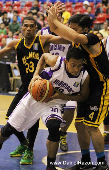 Judiciary Magis Guard Rodolfo Roboredo (C) battles to keep ball possession against the defense of Malacañang Patriots point guard Marlon Fernandez Berganio (R) and shooting guard Rodney Daniel (L) during the UNTV Cup Season 2 Second Round Eliminations at the Ynares Sports Arena, Pasig City, Philippines on 27 April 2014. (Maia Garciano | Photoville International)